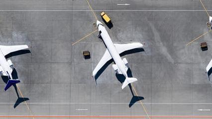 Aerial view of three airplanes at airport.